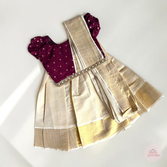 Traditional outfit with maroon blouse and gold saree on a white background